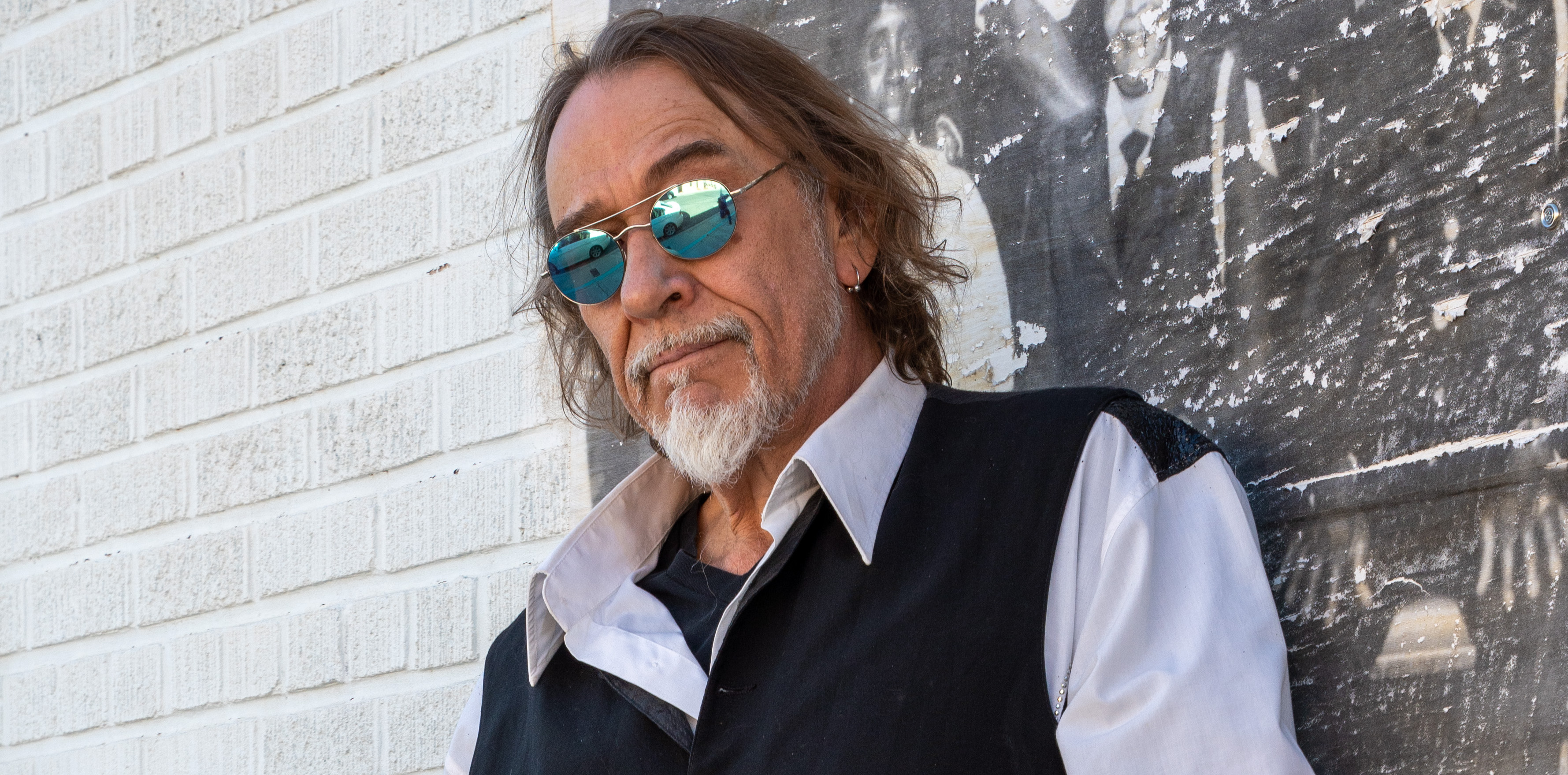 Eric in front of a cool painted brick wall